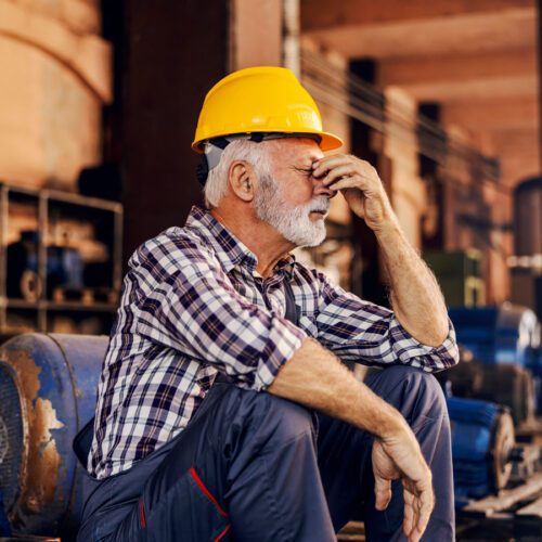 Older worker sitting in manufacturing environment
