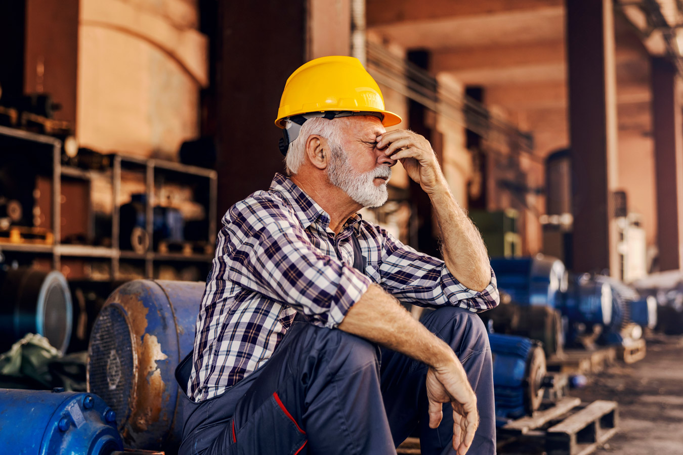 Older worker sitting in manufacturing environment
