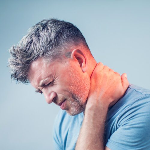 Middle aged man holding neck in pain