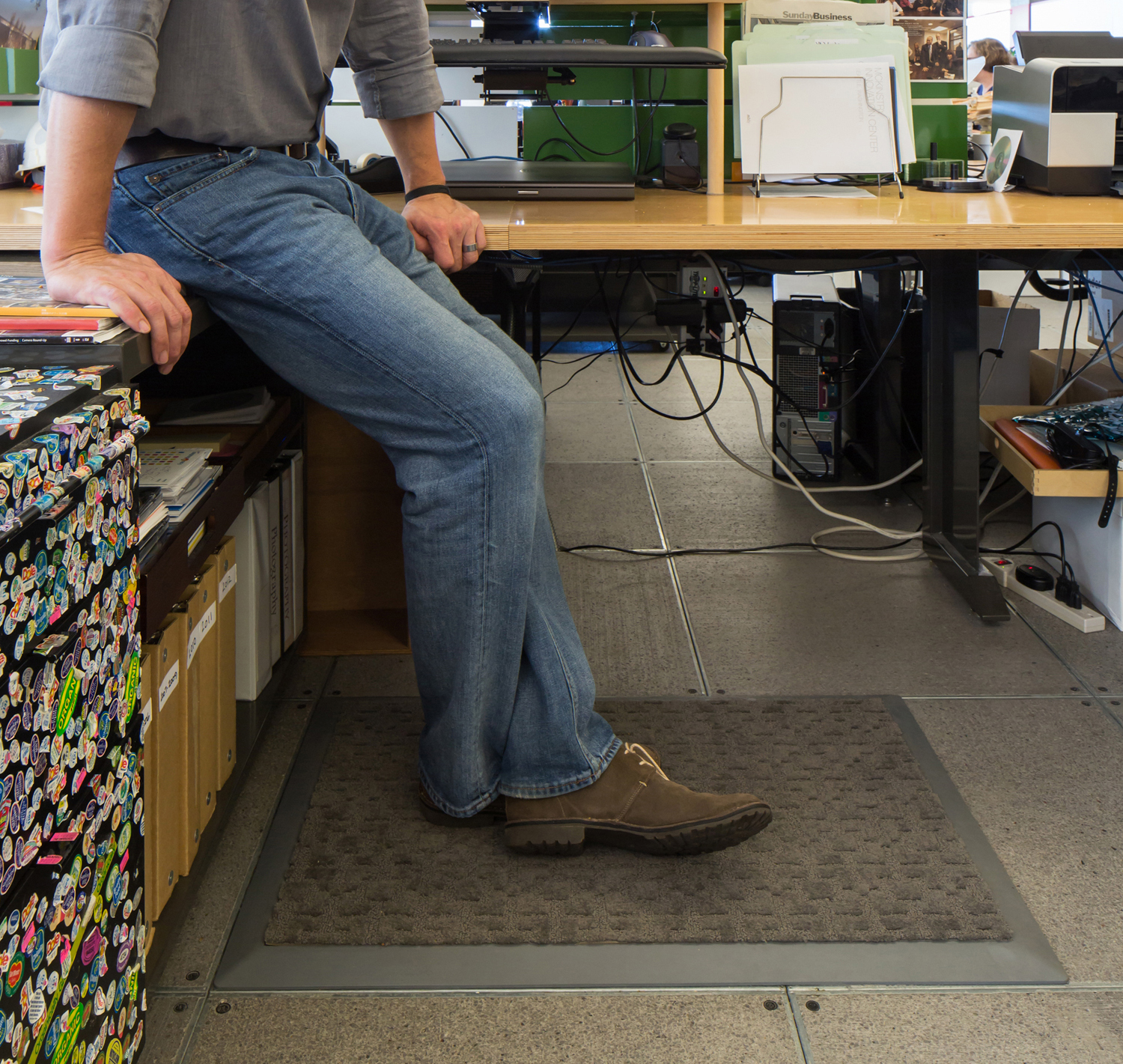 employee standing on mat while working on a standup desk
