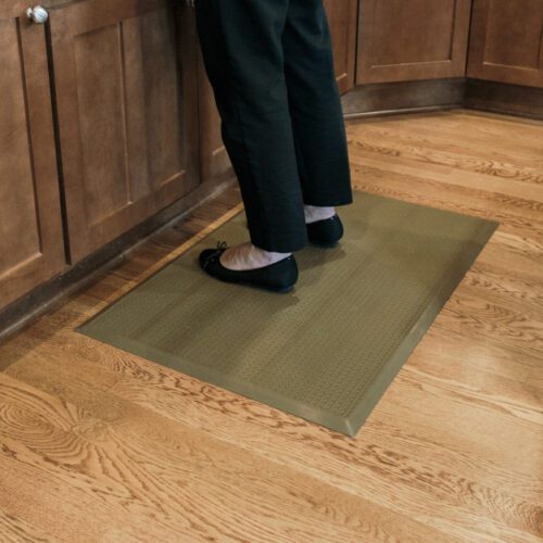 Woman standing on SmartCells mat in residential kitchen
