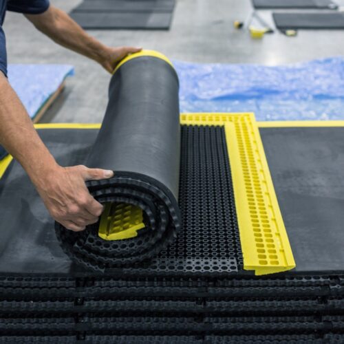 employee rolling up a smartcells custom anti-fatigue solution