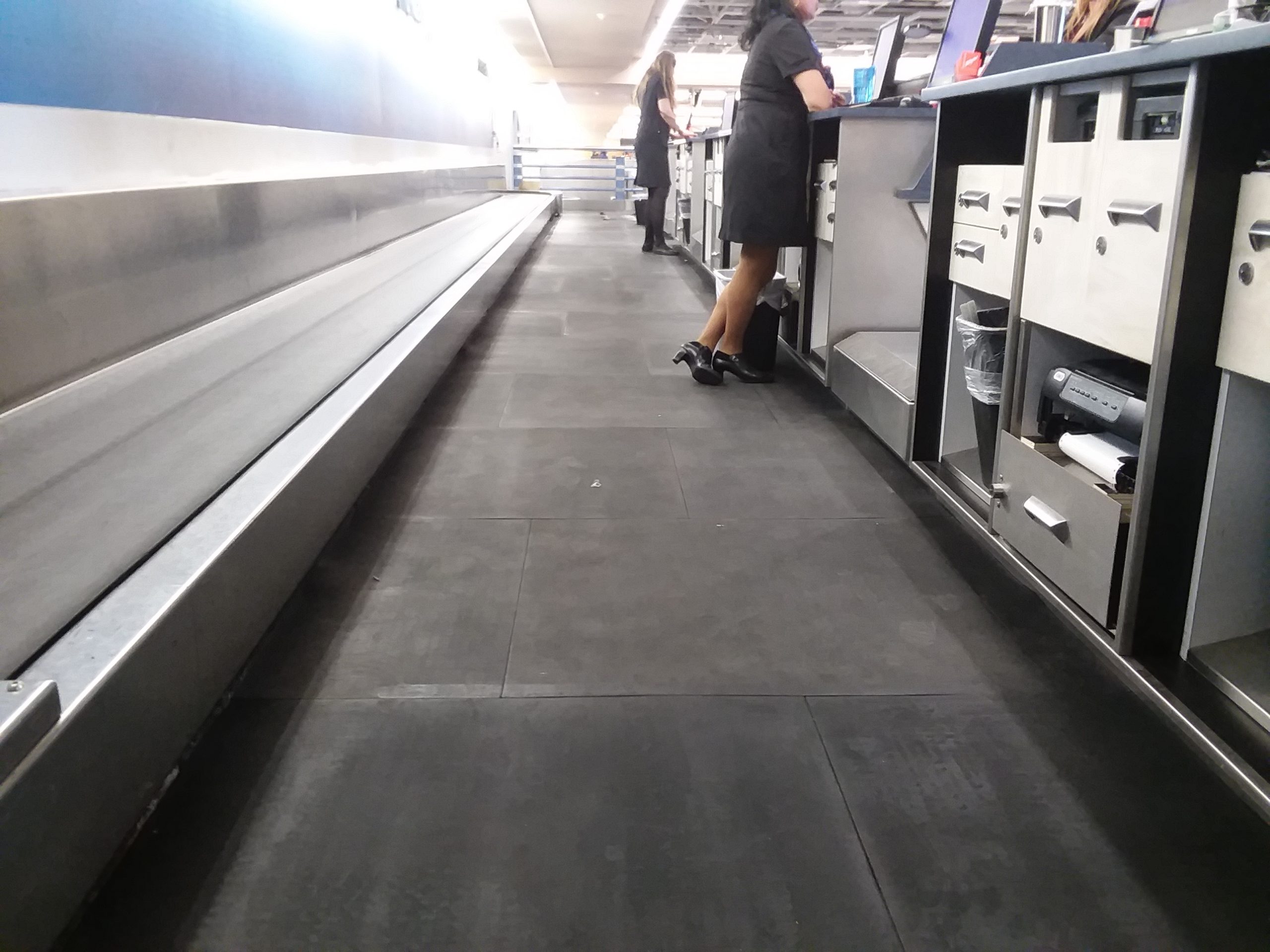 Airline employee working baggage drop off area standing on SmartCells flooring