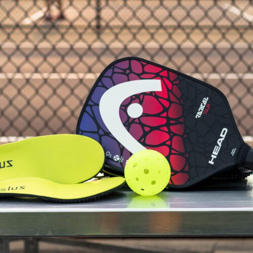 Zelus Insoles sitting next to pickleball paddle and ball