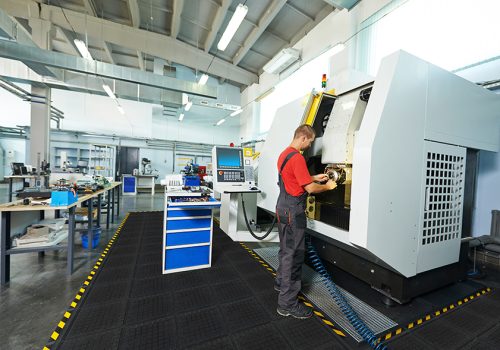 Hog-Heaven-III-Comfort-Modular-Tiles-in-use-website Employee working on heavy machinery