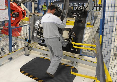 Hog-Heaven-in-use-industrial-striped-border-website Employee standing on mat using machinery